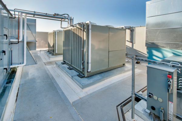 A perspective view shows several large industrial air handling units and HVAC equipment installed on a flat commercial roof with professional piping and electrical service boxes.